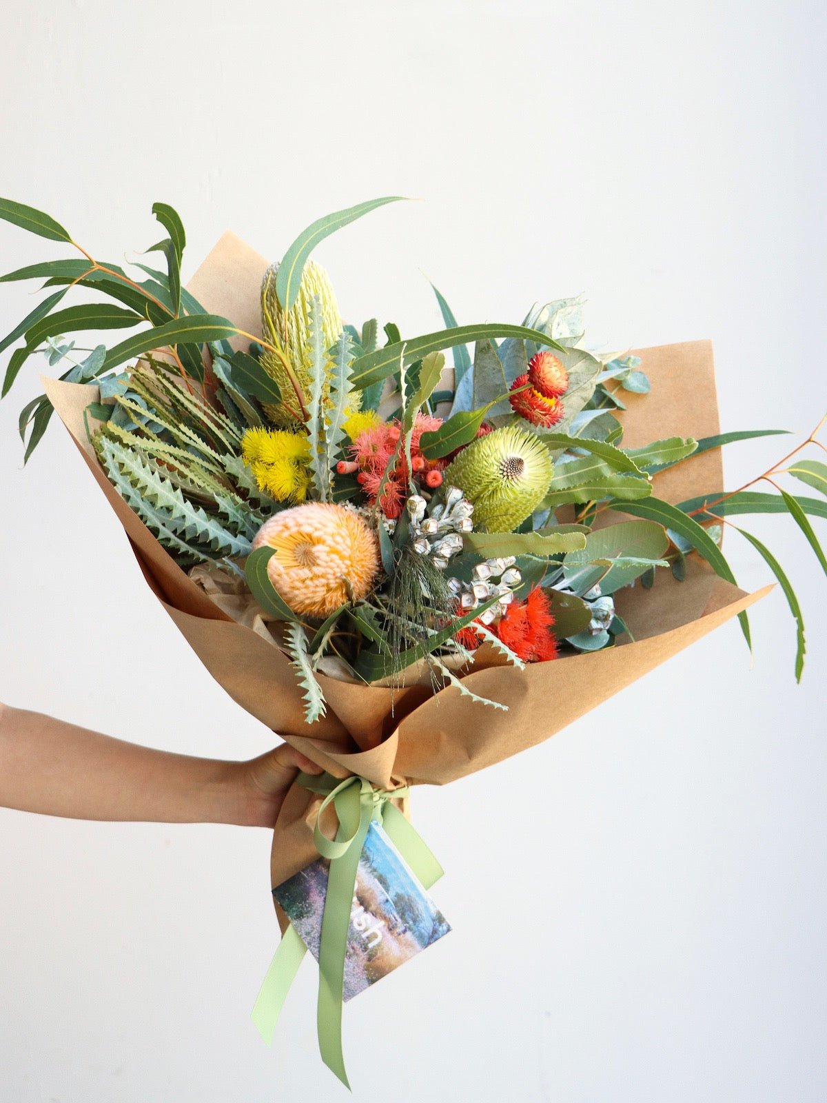 A small size bouquet of australian native flowers. The bouquet features banksias, flowering gum, strawflower and eucalyptus.