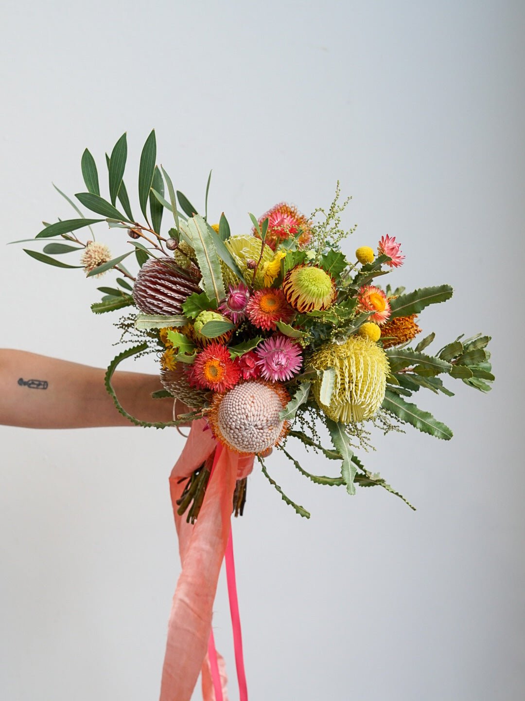 An Australian Native Bridal Bouquet. The bouquet pictured includes Banksia Menziesii, Banksia Burdettii, Straw flower, Hakea, Banksia Spinulosa, Billy buttons and Wattle.