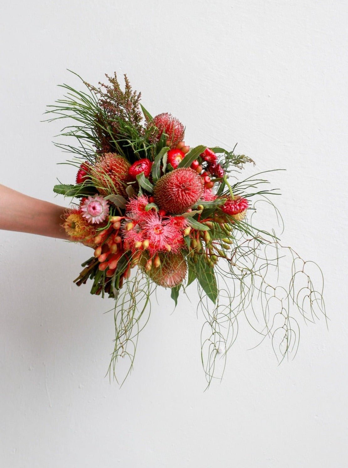 A bright example of a Bush wedding bouquet. The bouquet features Banksia Menziesii, strawflower, zig zag wattle, eucalyptus, banksia occidentalis.